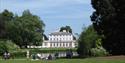 View of Frogmore House & Garden across the lake with people enjoying picnics