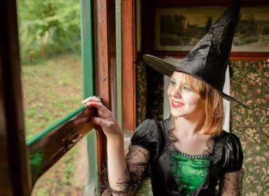 Isle of Wight, Things to Do, Isle of Wight Steam Railway, Wizard Week, Image of lady in witch costume looking out of carriage window.