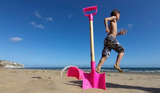 Boy next to bucket and spade on Yaverland Beach, Sandown, Isle of Wight, Things to Do