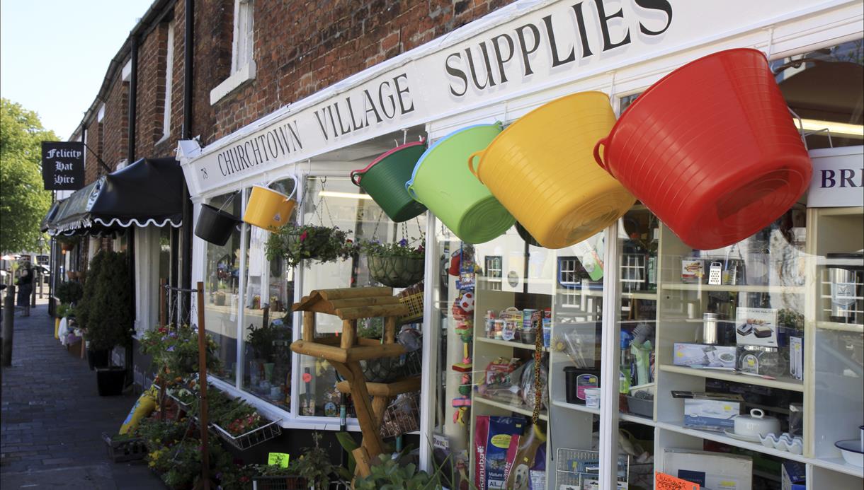 Different coloured buckets hang up outside a store from in Churchtown