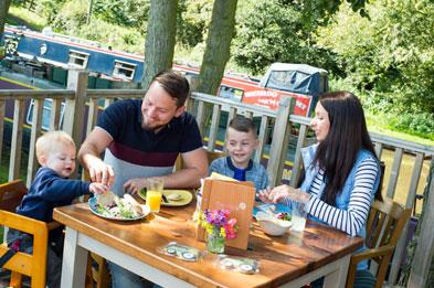 Family having lunch at Canalside Farm Cafe in the outdoor eating area.