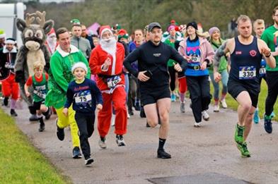 A group of runners, some in festive fancy dress, taking part in a fun run