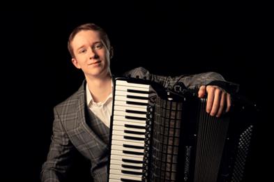 Image shows a musician with his accordion