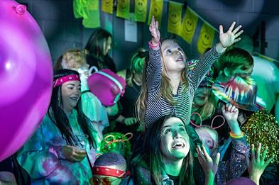 A girl on her mum's shoulders enjoys the show at the Big Fish Little Fish Family Rave, in Stafford, Staffordshire