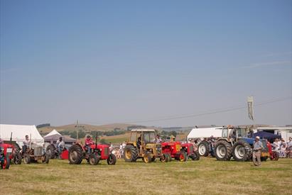Image shows a glorious day in the Staffordshire Peak District, with tractors lined up, ready for the Manifold Valley Agricultural Show to open