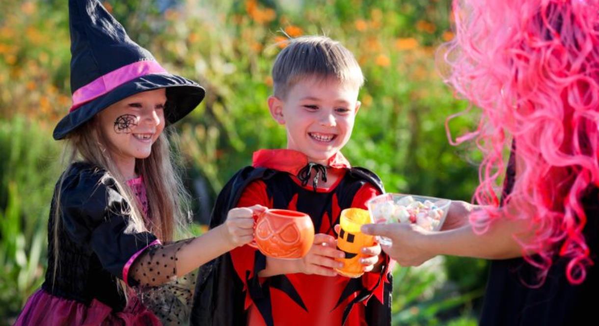 Children in Halloween costumes collecting some sweets