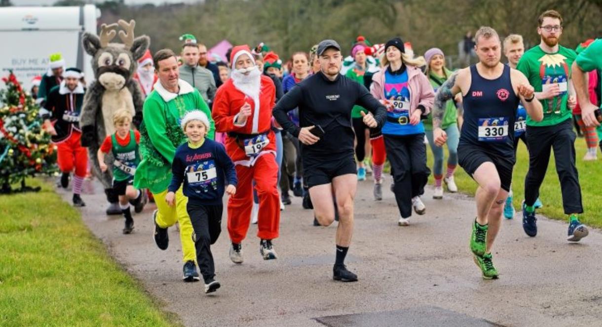 A group of runners, some in festive fancy dress, taking part in a fun run