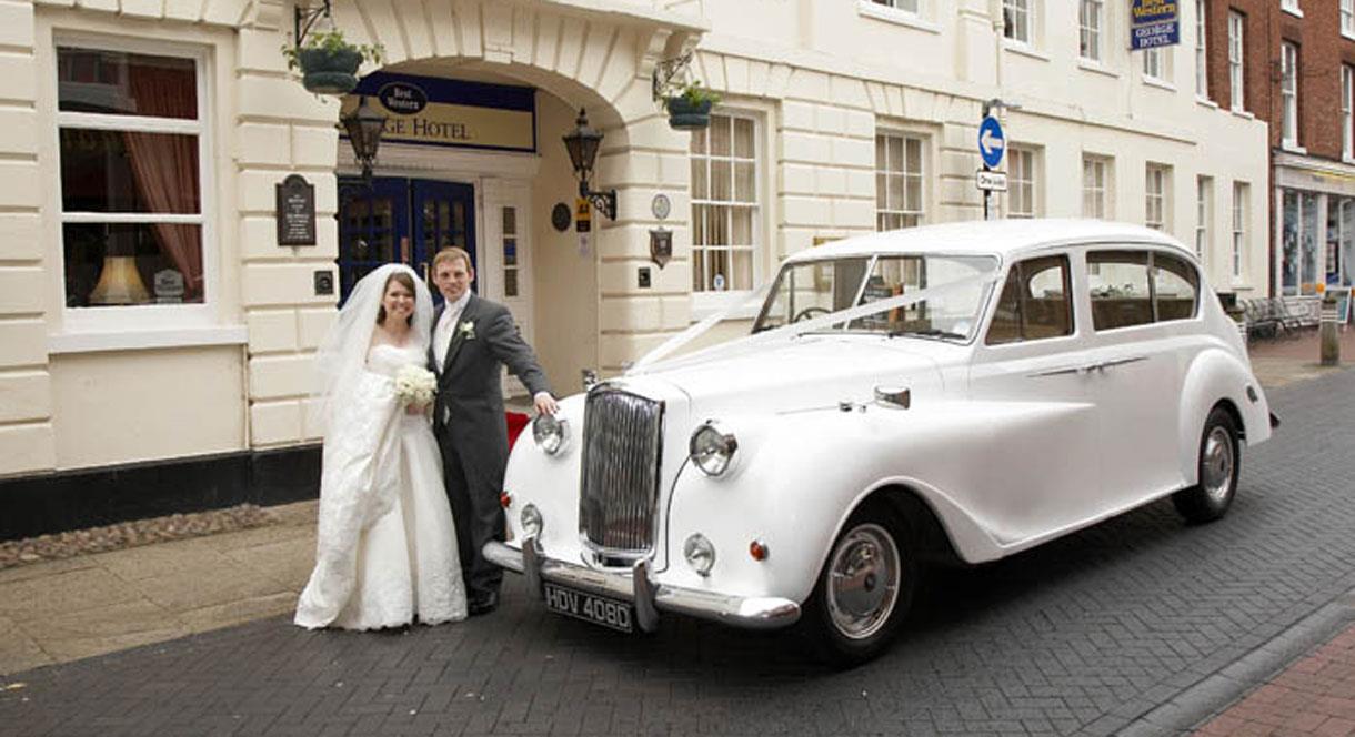 Classic Car with Bride and Groom outside the George Hotel.
