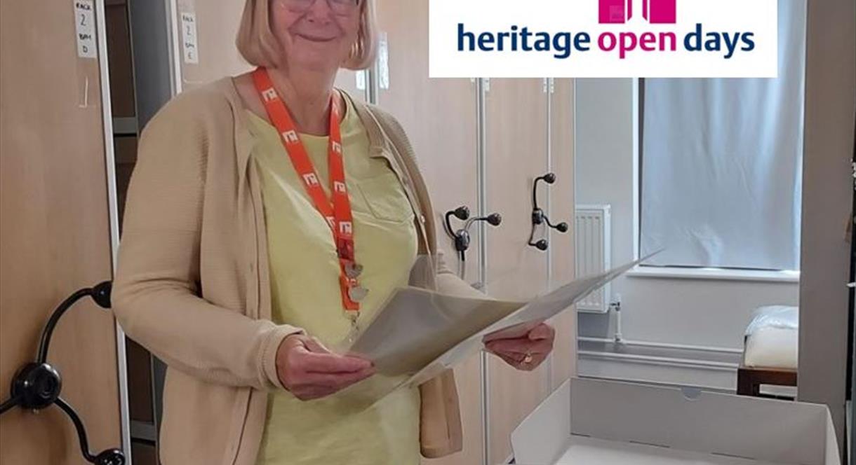 A woman stands outside Middleport Pottery's archives, with some old documents in her hands