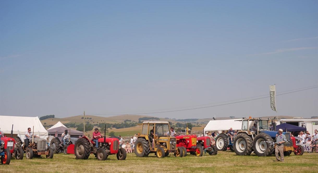 Image shows a glorious day in the Staffordshire Peak District, with tractors lined up, ready for the Manifold Valley Agricultural Show to open