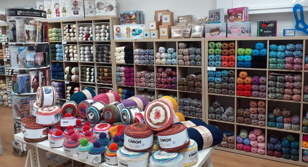 image of shop interior, shelves with different colours of yarn