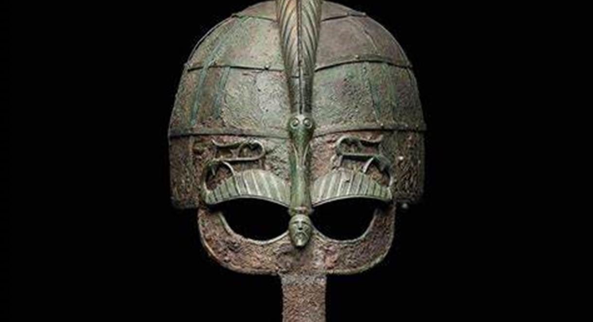 An ancient helmet against a black backdrop