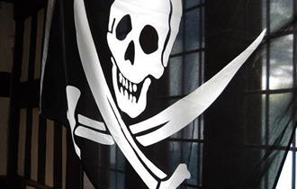 A pirate flag hanging up over a window