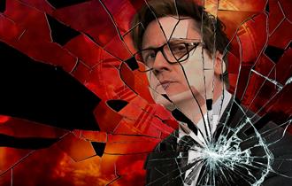 A promotional image for Ed Byrne's tour - a picture of Ed's reflection in a broken mirror