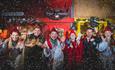 Image shows some of the performers from North Pole Adventure, in costumes, as snow falls down