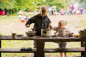 Two young children get their hands dirty in a mud kitchen at The Wolseley Centre, Staffordshire