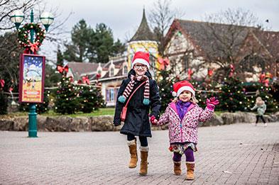 Young girls in Santa hats enjoying Festive Day Out at Alton Towers Resort in Staffordshire.
