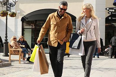 Couple with shopping bags at McArthurGlen Designer Outlet West Midlands, Cannock, Staffordshire.