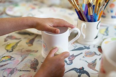 Kids decorate mugs with sponges and paint at Emma Bridgewater Factory. Photocredit:VisitBritain&DianaJarvis