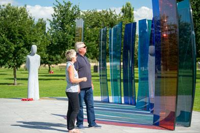 Couple reading the inscription on the Naval Services Memorial at National Memorial Arboretum
