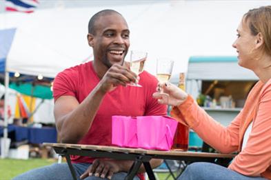 Couple seated at table drinking wine alfresco at Stone Food & Drink Festival