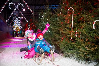 Children sledging on ice track at SnowDome for Santa's Winter Wonderland