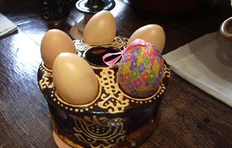Image shows five eggs on a pretty stand, on a table