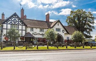 Image shows the front of The Dog & Doublet Inn, taken on a sunny day