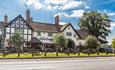 Image shows the front of The Dog & Doublet Inn, taken on a sunny day