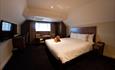 Image shows a spacious bedroom at The Dog & Doublet Inn, with plasma screen and large double bed
