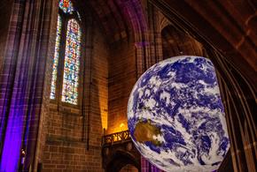 Image shows a huge model of Planet Earth, suspended from the ceiling of a Cathedral