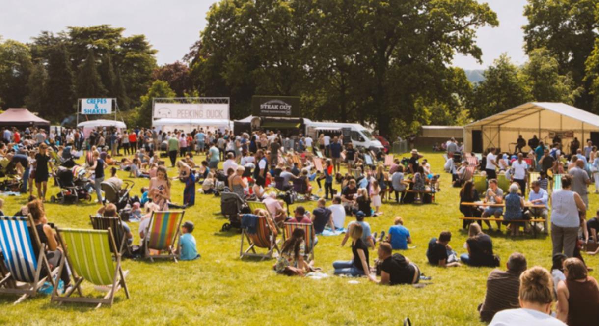 A host of great food stalls, with visitors relaxing in the sunshine, at The Trentham Estate, Staffordshire