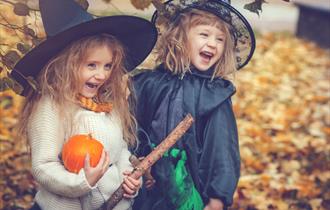Two children in fancy dress with their pumpkin haul, at Tittesworth Water, Staffordshire