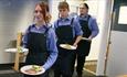 Image shows Hammersley Restaurant learners bringing dishes out from the kitchen