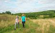 Two friends walk up Battlestead Hill, on the National Forest Way in Staffordshire