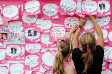 Two Race 4 Life runners leave their messages on the wall at The Trentham Estate, Staffordshire