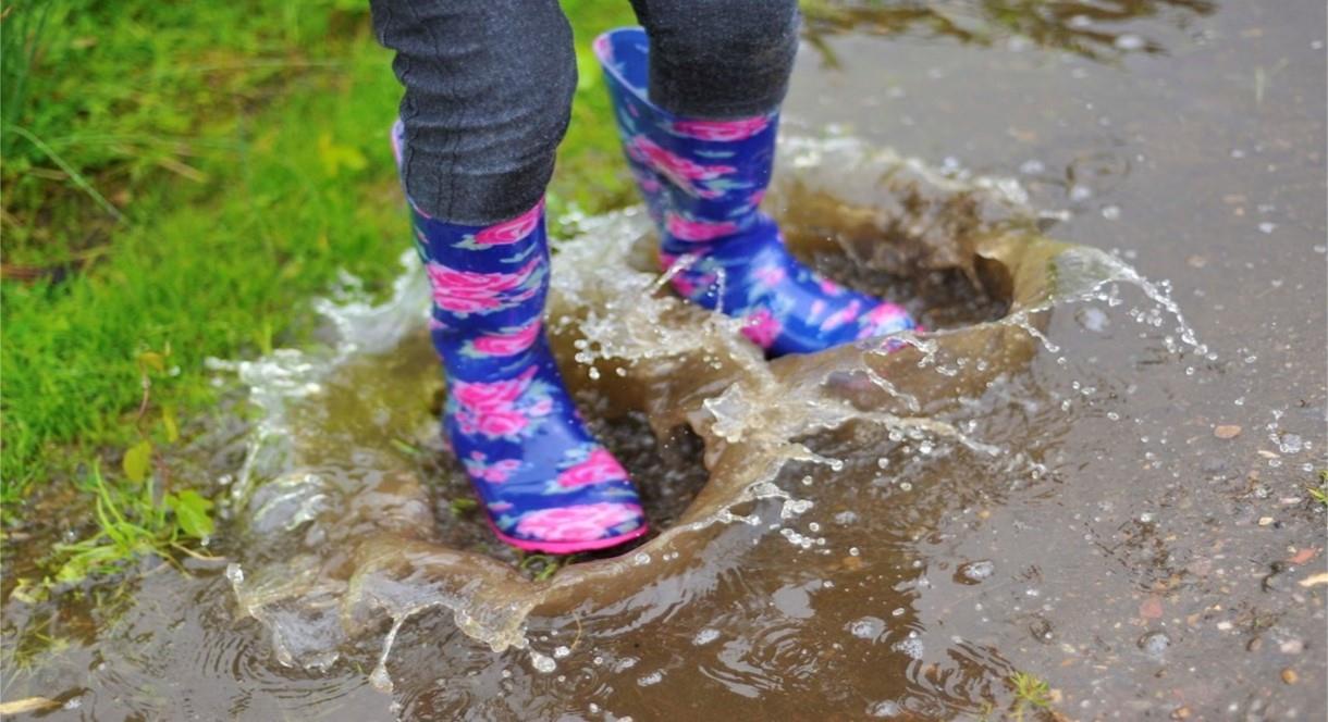 A pair of young feet making a splash in a puddle