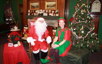 Santa and an elf in the parlour at The Brampton Museum, Staffordshire