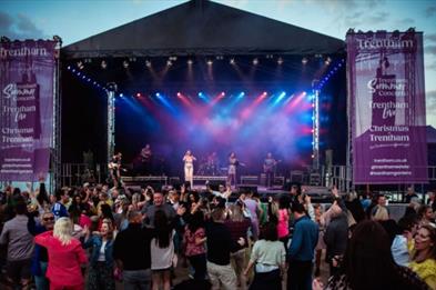 Acts perform on stage in front of a big crowd at The Trentham Estate, Staffordshire