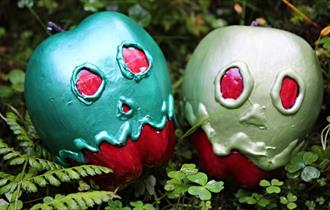 Two poisoned apples sitting on a bed of lush green moss
