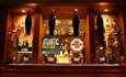 Image shows the inviting, well-stocked bar at Ye Olde Rock Inn, with its selection of ales and spirits