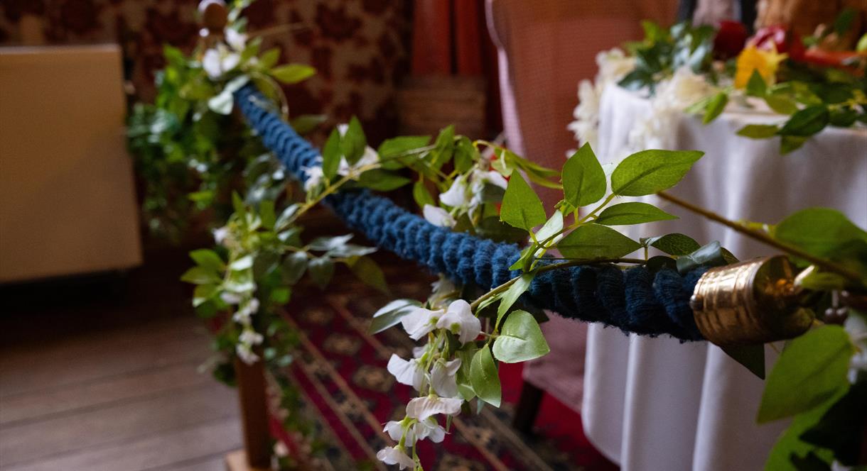 Image shows a rope barrier, with flowers attached