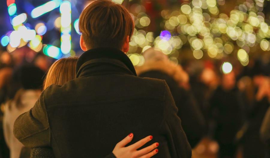 Couple looking out over Christmas outdoor gathering