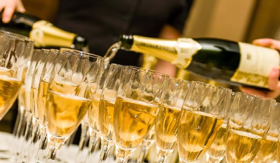 Champagne glasses being filled on a table