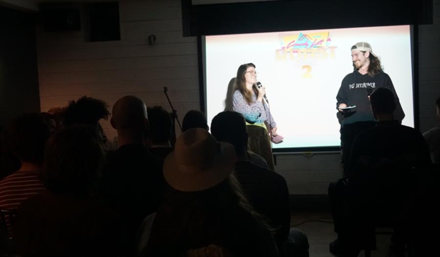 2 Comedians trading jokes with each other in front of a live audience