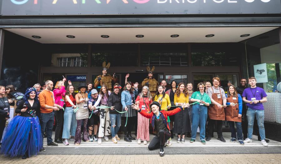 A large group of people stood in a shop front doorway