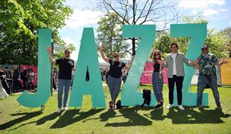 People stood next to big JAZZ sign.