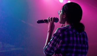 Woman onstage holding a microphone