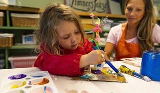 a young girl and a woman play with paints