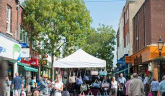 Visitors and shoppers walking around Poole market